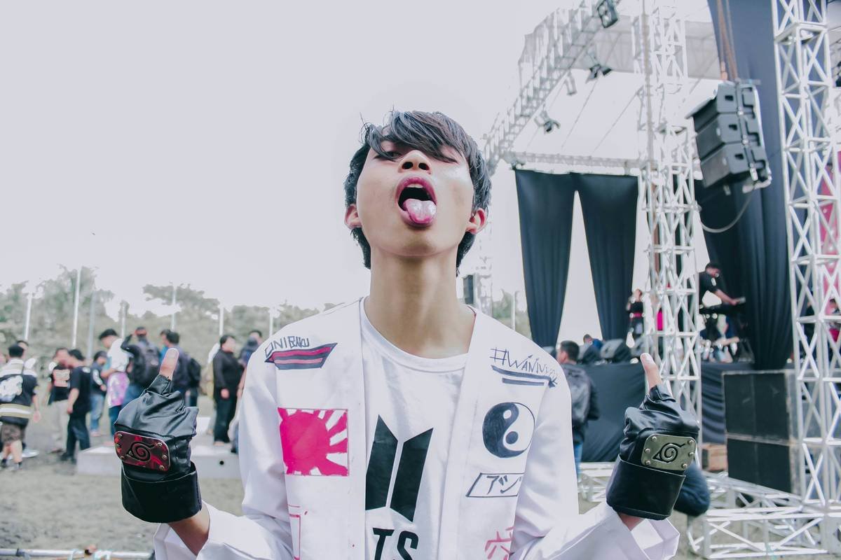 a young man standing in front of a stage with his mouth open
